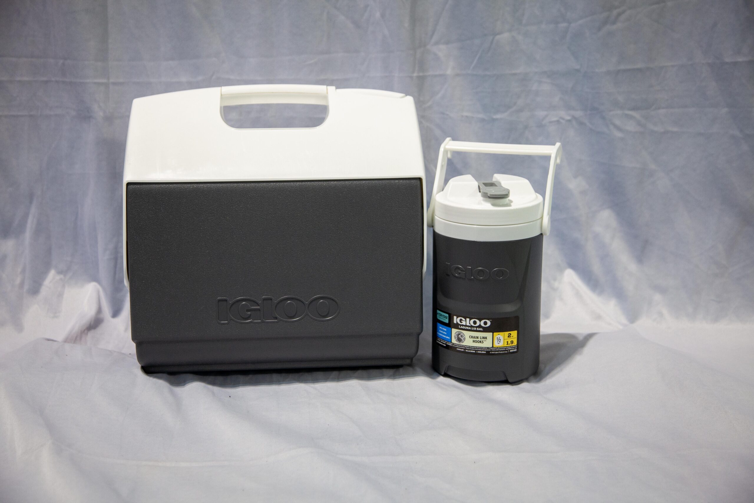 Igloo cooler and water jug set featuring a gray cooler with a white lid and a gray water jug with a white cap, ideal for outdoor activities and keeping items cold.