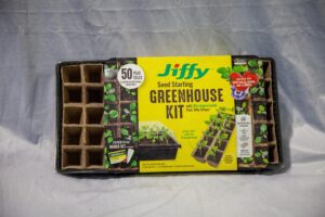 Jiffy Seed Starting Greenhouse Kit featuring 50 biodegradable peat cells designed for growing individual seedlings, perfect for vegetables, herbs, and flowers. The packaging highlights the kit's easy transplanting features and includes a SUPERthrive bonus set.