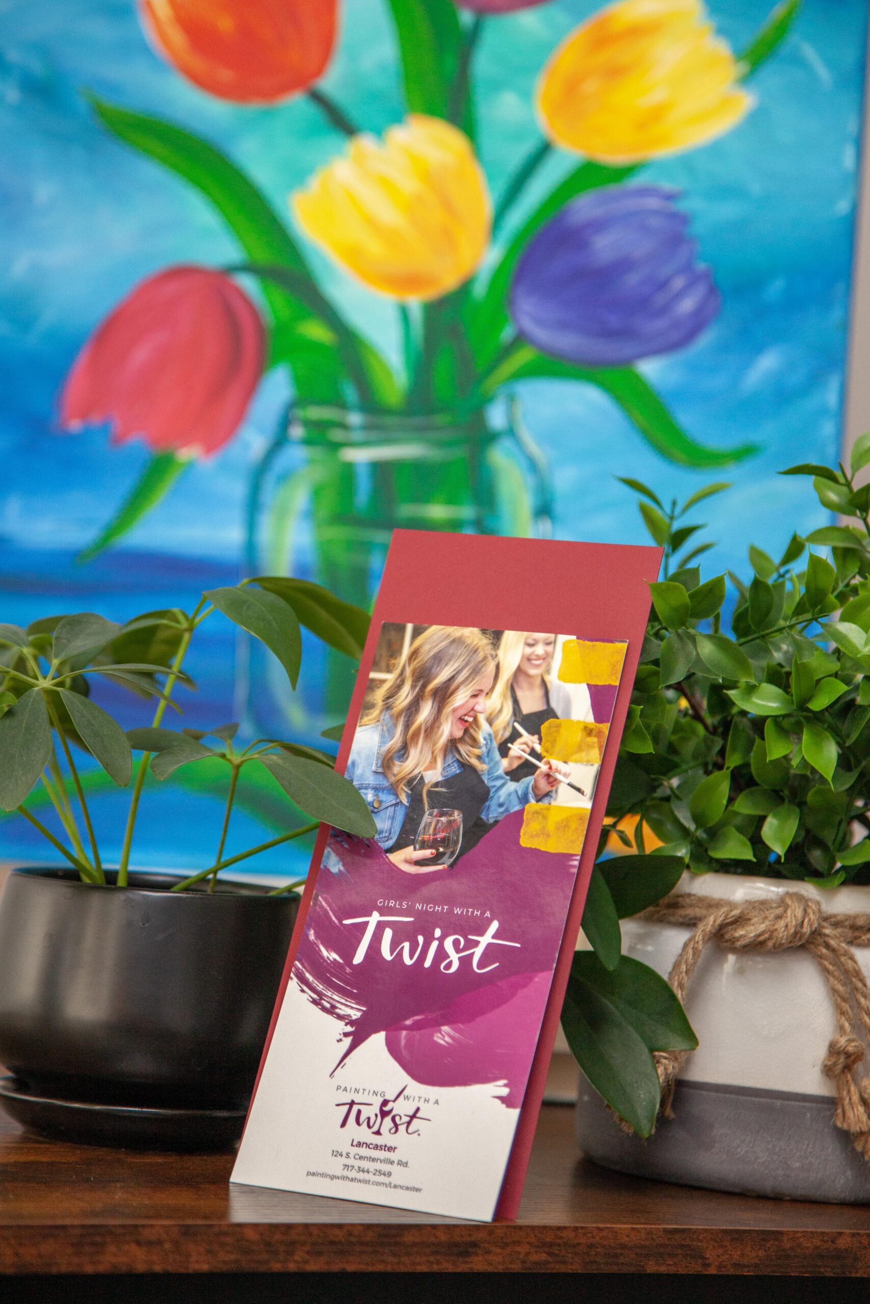 Flyer for Painting with a Twist event, surrounded by vibrant plants and colorful tulip artwork.