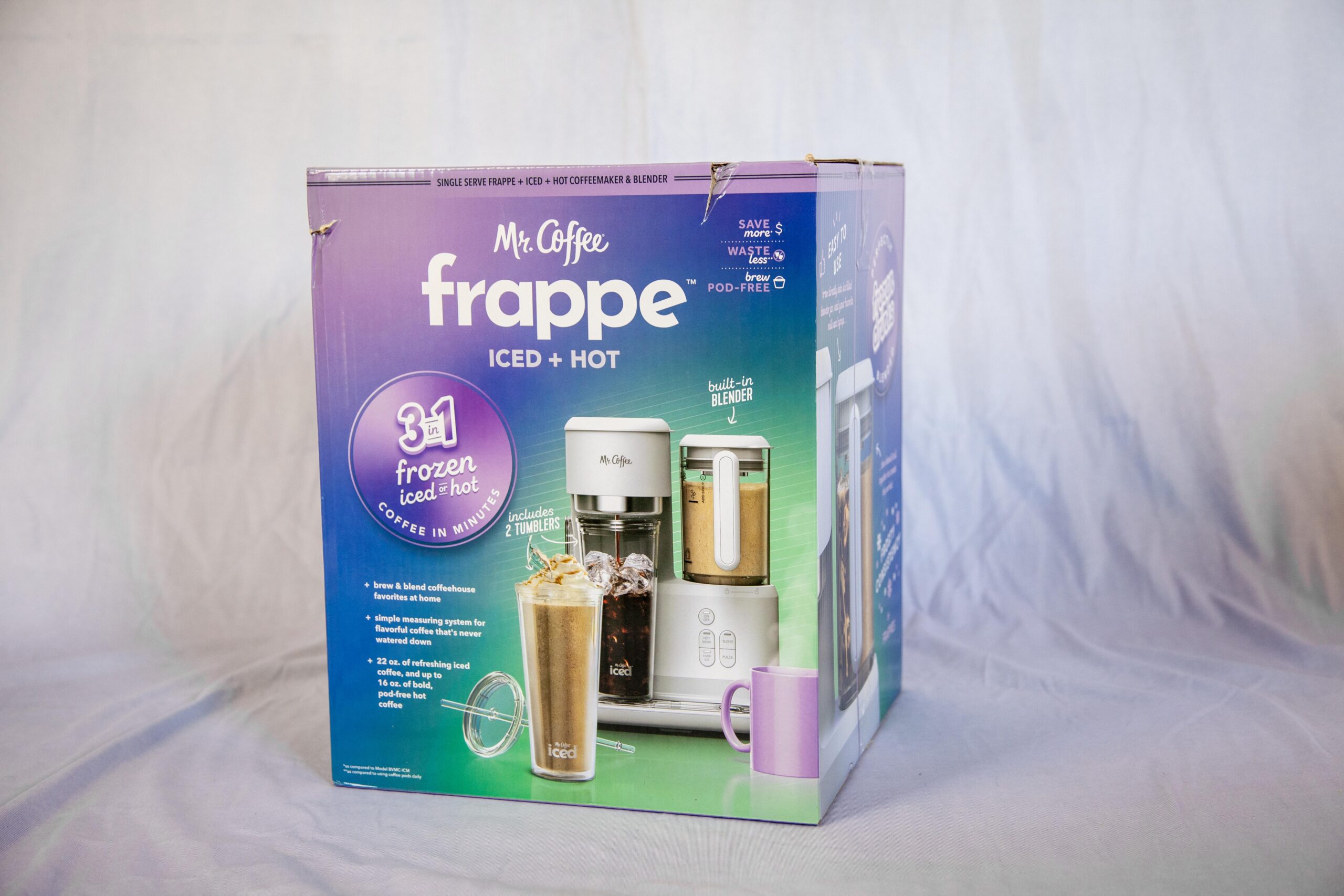 Mr. Coffee Frappe Iced + Hot coffee maker box featuring a 3-in-1 brewer for frozen iced and hot coffee. Includes built-in blender and two tumblers, designed for quick preparation of refreshing iced coffee and bold hot coffee, with a simple measuring system for flavor customization.