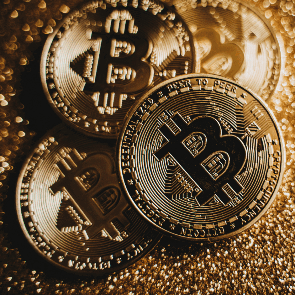 Close-up of shiny Bitcoin coins stacked on a sparkling surface, representing cryptocurrency and digital finance.