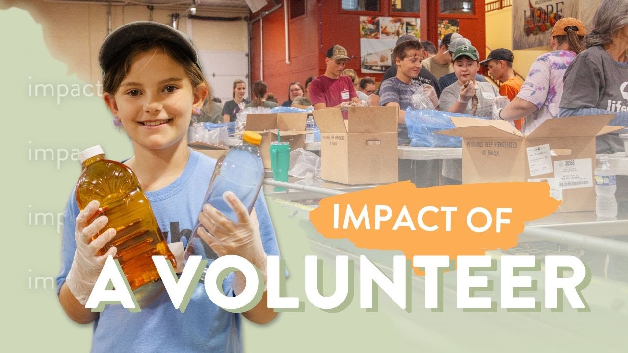 Young volunteer holding two bottles while participating in a community service event, surrounded by other volunteers packing items in a warehouse setting. The image highlights the positive impact of volunteering on local communities.