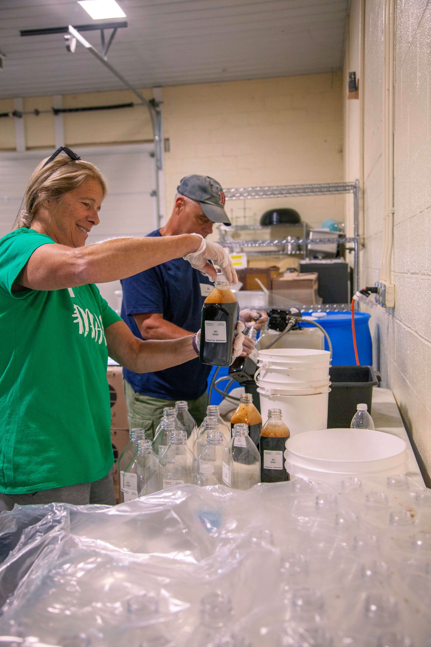 Volunteers preparing and bottling liquid samples in a lab setting, showcasing teamwork and attention to detail during the packaging process.