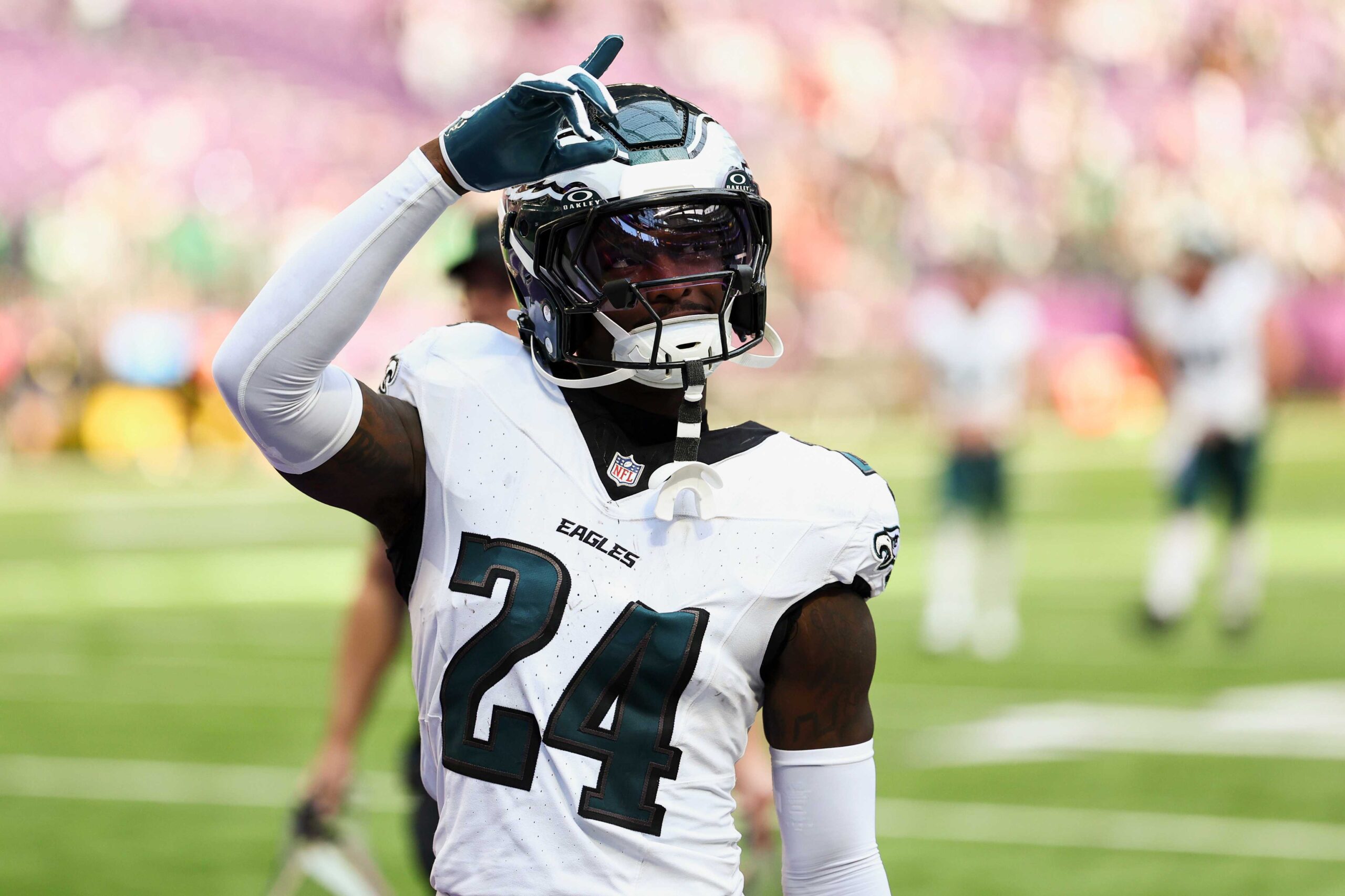 Philadelphia Eagles player celebrating on the field, wearing jersey number 24, during an NFL game. The player is making a gesture with one hand raised, showcasing team spirit.